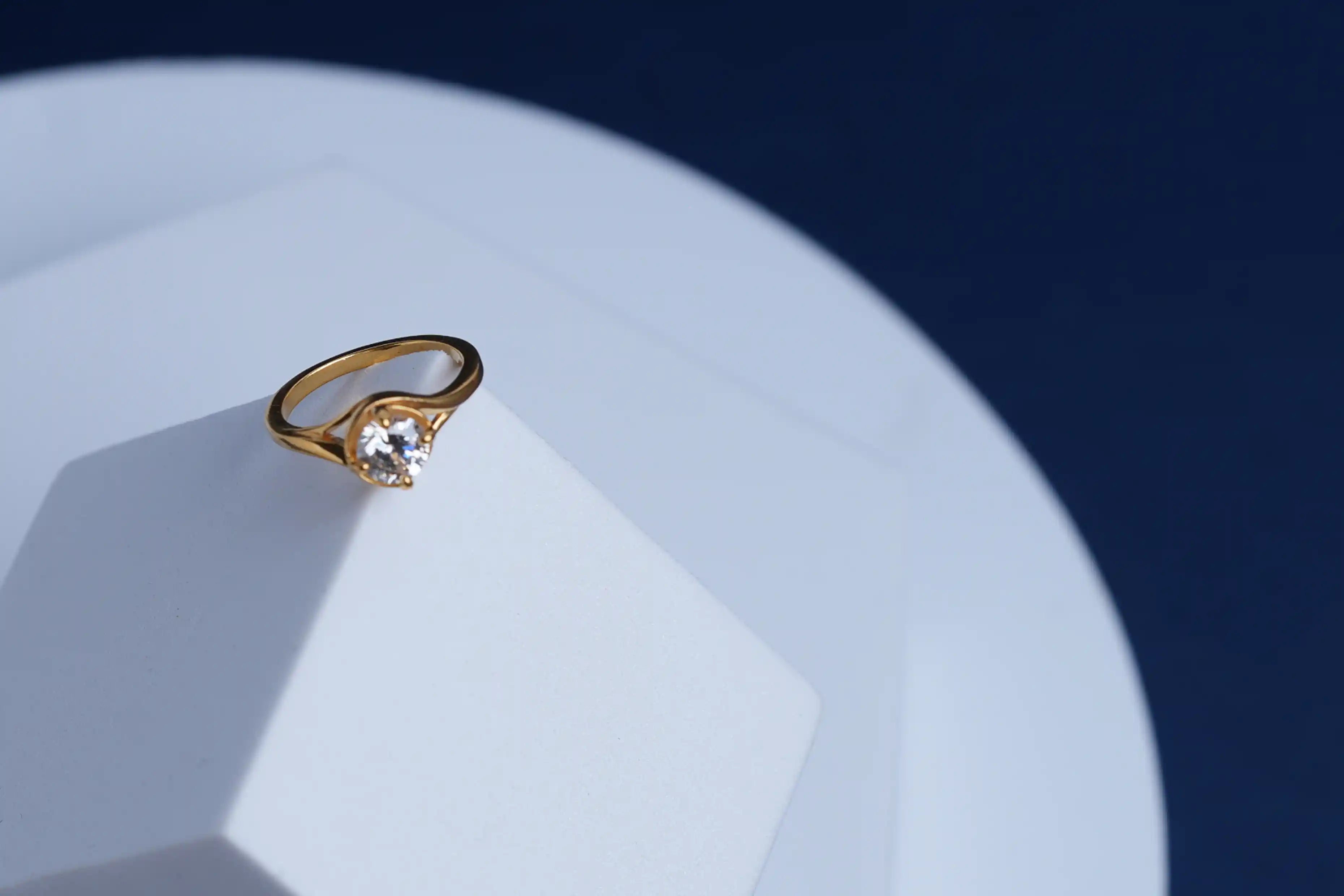 Gold ring on a white plate with a dark blue background